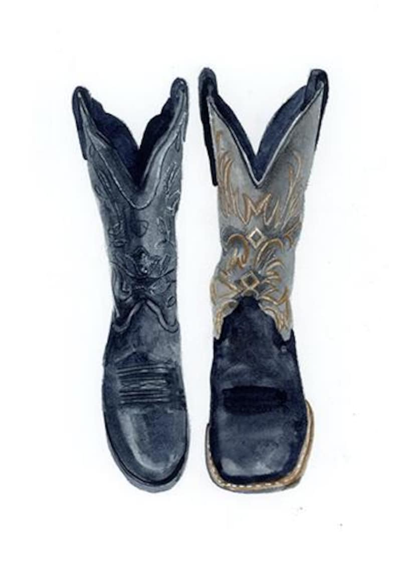 K&ouml;nnte beinhalten: Ein Paar schwarze Cowboy-Stiefel mit aufwendigen N&auml;hten und einem goldenen Design am Schaft. Ein Stiefel zeigt nach vorne, der andere nach hinten.