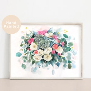 May include: A watercolour painting of a bouquet of white, pink and coral roses with green succulents and eucalyptus leaves. The flowers are arranged in a loose, flowing style, and the background is a soft blue watercolour wash.