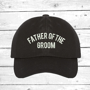May include: Black baseball cap with white embroidered text that reads "Father of the Groom".