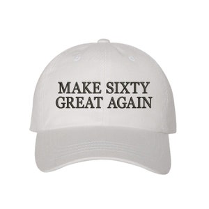 May include: White baseball cap with black embroidered text that reads "Make Sixty Great Again".