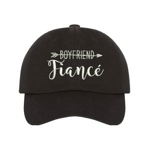 May include: Black baseball cap with white embroidered text that reads "Boyfriend Fianc&eacute;" with an arrow pointing to the right.