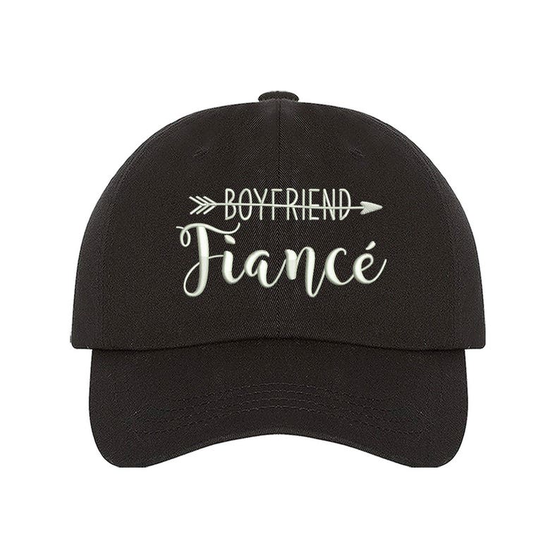 May include: Black baseball cap with white embroidered text that reads "Boyfriend Fianc&eacute;" with an arrow pointing to the right.