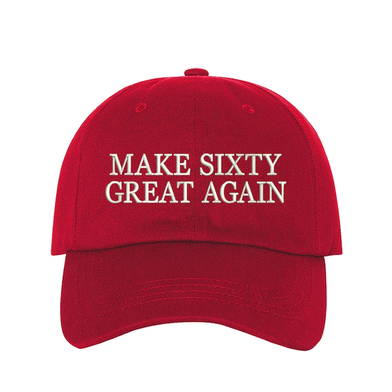 May include: Red baseball cap with white embroidered text that reads "MAKE SIXTY GREAT AGAIN".
