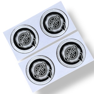 Op de afbeelding: Vier Chrysler embleem stickers. Elke sticker heeft een zwart-wit Chrysler logo in een cirkelvormig ontwerp. De stickers zitten op een witte achtergrond, met een glanzende, heldere, gewelfde afwerking.