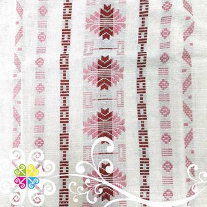 May include: White fabric with a repeating pattern of pink and red geometric shapes. The fabric has a woven texture.