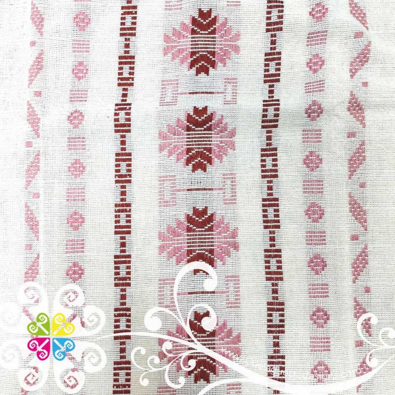 May include: White fabric with a repeating pattern of pink and red geometric shapes. The fabric has a woven texture.