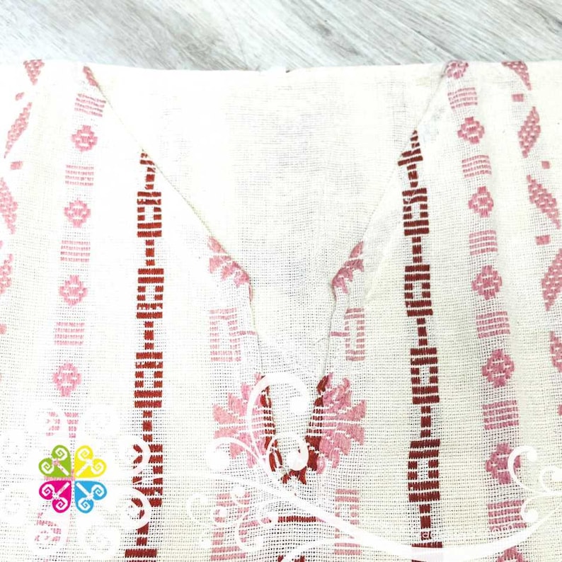 May include: White cotton fabric with pink and red embroidered geometric patterns. The fabric has a woven texture and a slightly sheer appearance.