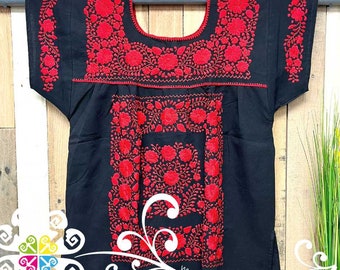 May include: Black embroidered blouse with red floral designs. The embroidery is around the neckline and down the front of the blouse. The blouse has short sleeves.