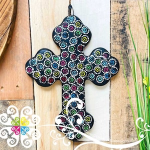 May include: A black wooden cross with a colorful dot pattern. The dots are in various shades of blue, green, yellow, pink, and white. The cross is a religious symbol and would make a unique and decorative addition to any home.