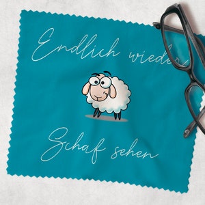 Könnte beinhalten: Ein blaues Mikrofaser-Reinigungstuch mit einer weißen Schaf-Illustration und dem Text "Endlich wieder Schaf sehen".