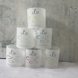Könnte beinhalten: Sechs weiße zylindrische Kerzenhalter mit einem Fischschwarm-Design und dem Namen "Lea" sowie dem Datum "04.06.2023" auf jedem.