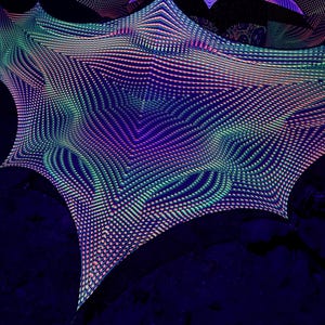 Puede incluir: Instalación de arte abstracto con un fondo azul oscuro. La instalación presenta estructuras en forma de estrella compuestas por una cuadrícula de pequeños puntos brillantes. Los puntos son en tonos de rosa, verde y azul, creando un patrón geométrico vibrante.