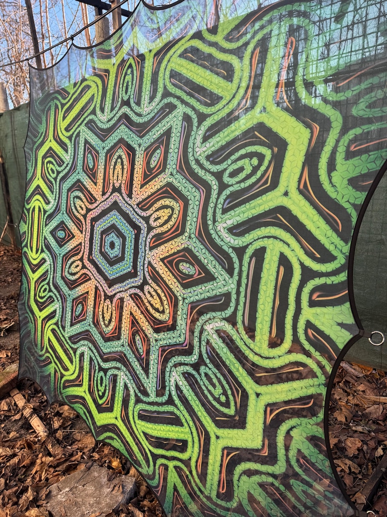 May include: A green, orange, and black patterned mesh canopy with a geometric design. The canopy is made of a lightweight, breathable material and is perfect for creating shade in a backyard or garden.