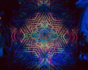May include: A black background with a large, colourful, geometric design painted in neon colours. The design is symmetrical and features a star shape in the centre. The design is illuminated by black lights.