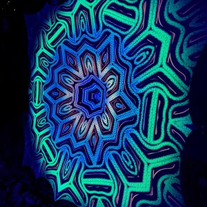May include: A blacklight reactive tapestry with a colorful mandala design in shades of blue, green, and pink. The mandala features intricate geometric patterns and a central starburst.
