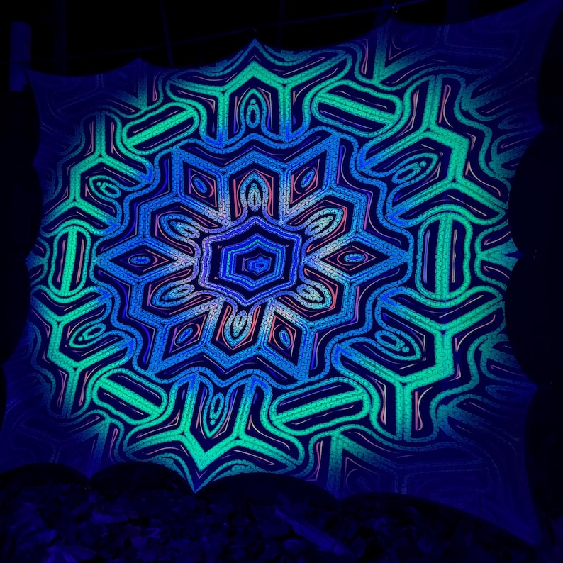 May include: A blacklight reactive tapestry with a blue, green, and pink mandala design. The mandala is intricate and detailed, with a variety of geometric shapes.
