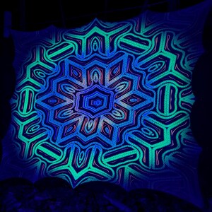 May include: A black and white mandala with a blue, green, and pink glow. The mandala is made of intricate geometric patterns.