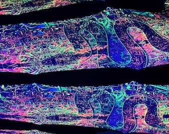 May include: Three pieces of fabric with a psychedelic pattern in shades of green, pink, and blue. The fabric is glowing under a black light.