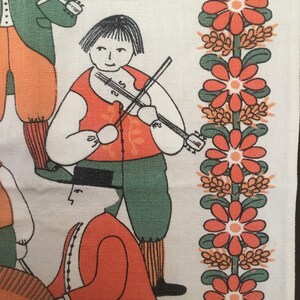 May include: A vintage fabric with a folk art design featuring a group of people playing musical instruments. The design includes a person playing a violin, a person playing a flute, and a person playing a drum. The fabric is white with orange, green, and black accents. The fabric has a border of orange flowers with green leaves.