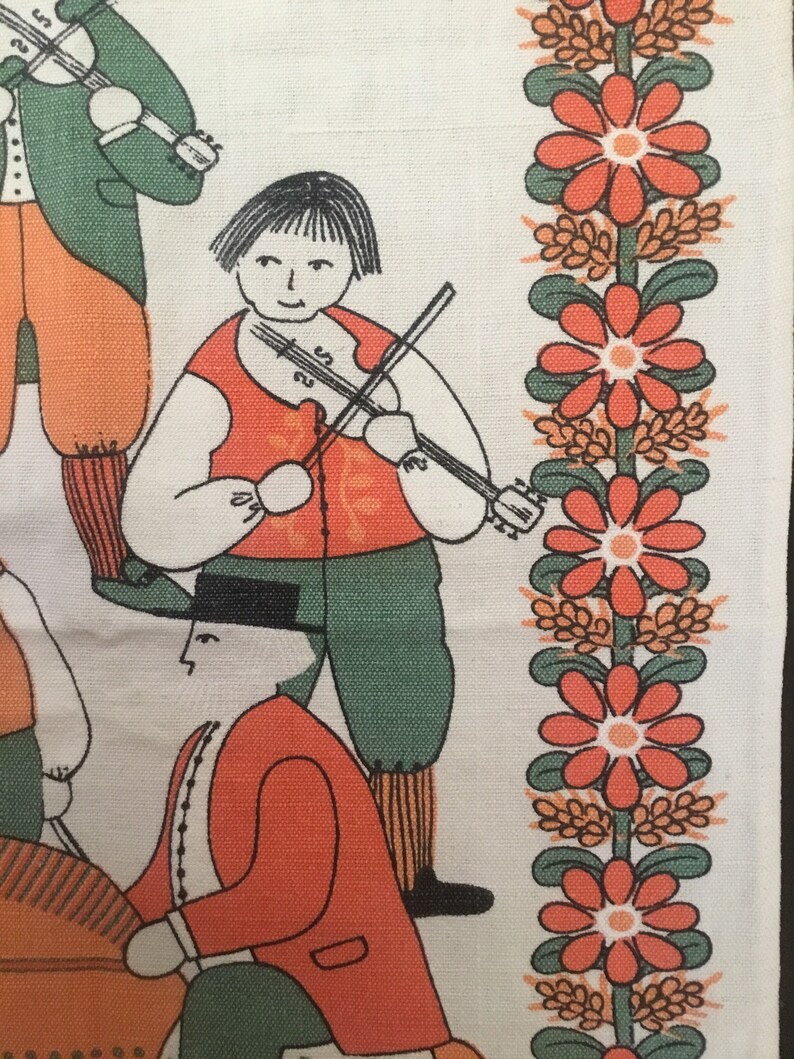 May include: A vintage fabric with a folk art design featuring a group of people playing musical instruments. The design includes a person playing a violin, a person playing a flute, and a person playing a drum. The fabric is white with orange, green, and black accents. The fabric has a border of orange flowers with green leaves.