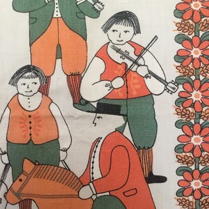 May include: A vintage fabric with a folk art design featuring four figures. Two figures are playing violins, one is riding a rocking horse, and one is standing. The figures are dressed in green, orange, and red clothing. The background is a white fabric with a border of red flowers.
