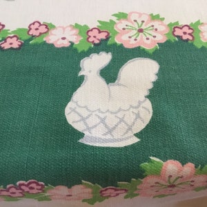 May include: White chicken illustration on a green background with a pink floral border. The chicken is in a basket with a white and grey pattern.