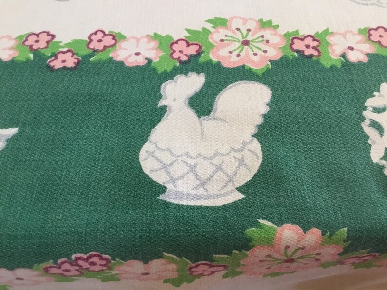 May include: White chicken illustration on a green background with a pink floral border. The chicken is in a basket with a white and grey pattern.