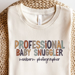 Newborn Photographer Shirt | Professional Baby Snuggler TShirt | Cute Photography Gift Snuggling Babies | Studio Newborns Photo Shoot Tee