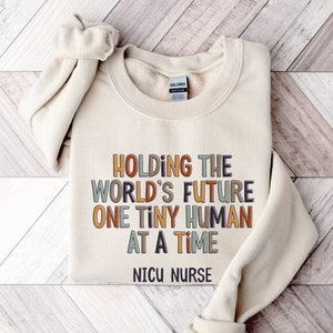 NICU Nurse Sweatshirt | Baby Nursery The World's Future Neonatal Crewneck Shirt | New Grad LPN Nursing Graphic Tee | Gift for Nurses Week