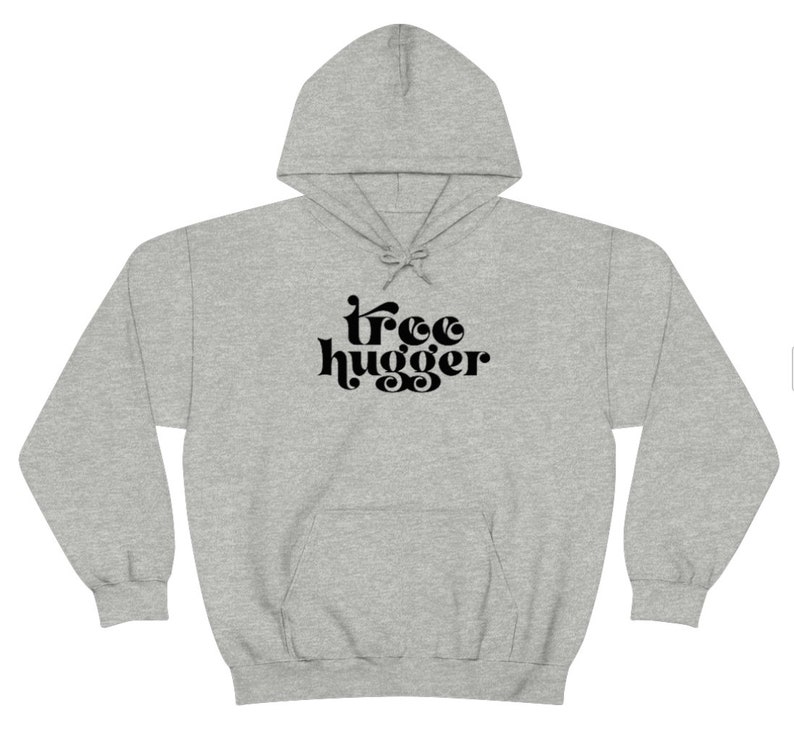 Puede incluir: Una sudadera con capucha gris claro con cord&oacute;n y bolsillo delantero. La sudadera presenta el texto negro "tree hugger" en una fuente retro. Esta sudadera informal es perfecta para los amantes de la naturaleza.