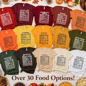 May include: A collection of fourteen short-sleeve t-shirts in various colors, each featuring a nutritional facts label graphic for a different Thanksgiving food item, including apple pie, cranberry sauce, ham, pumpkin pie, and mashed potatoes.