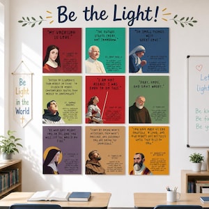 Op de afbeelding: Een wanddisplay met negen rechthoekige posters met illustraties van heiligen en historische figuren, elk met een citaat en naam. De tekst Be the Light! staat erboven en een banier bevat de tekst Be Light in the World.