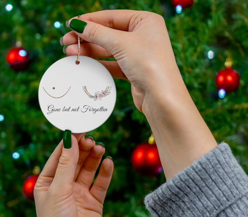 May include: White ceramic ornament with a floral design and the text "Gone but not Forgotten".