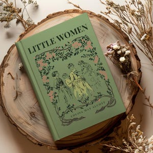 Peut inclure: Un livre à couverture rigide intitulé "LITTLE WOMEN" de Louisa May Alcott, avec une couverture verte ornée d'une illustration de personnages et de motifs floraux. Le livre est posé sur une tranche de bois, entouré de fleurs séchées.
