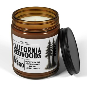 May include: A brown glass jar candle with a black lid. The label reads "California Redwoods No. 380" with a graphic of two trees. The candle is inspired by the towering giants and ancient groves.