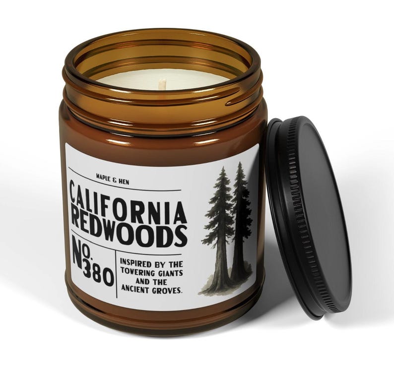 May include: A brown glass jar candle with a black lid. The label reads "California Redwoods No. 380" with a graphic of two trees. The candle is inspired by the towering giants and ancient groves.