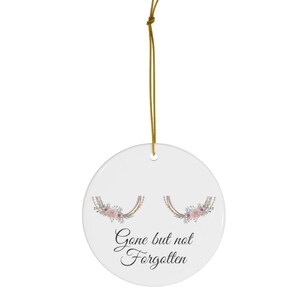 May include: White ceramic ornament with a floral design and the text "Gone but not forgotten".