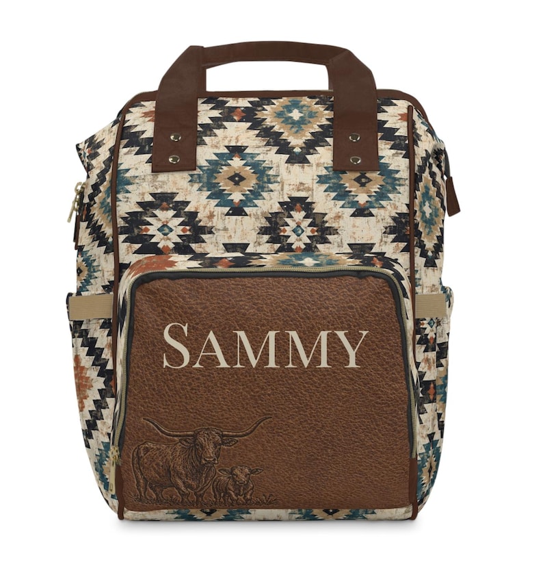 May include: A backpack with a Southwestern pattern in beige, brown, and blue. The front pocket is brown with the name "SAMMY" in white and a longhorn illustration. Features a top handle and side pockets.