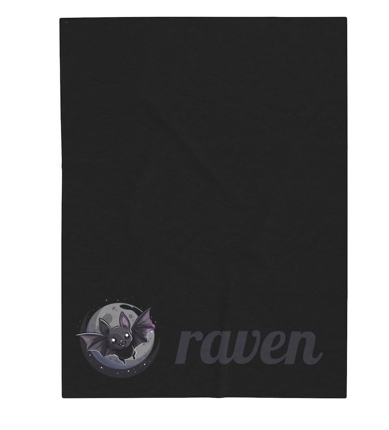 May include: Black blanket featuring a cartoon bat illustration in a circle with a moon and stars. The word "raven" is printed in a dark gray font. The blanket is a solid black color.