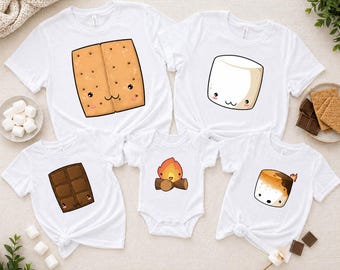 May include: White t-shirts and a onesie featuring cute cartoon s'mores ingredients: a graham cracker, marshmallow, chocolate bar, and campfire. The shirts are short-sleeved and suitable for family matching outfits. Marshmallows, chocolate, and graham crackers are also visible.