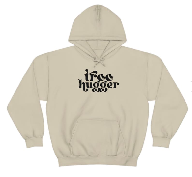 Puede incluir: Una sudadera con capucha beige con cord&oacute;n y bolsillo delantero. Las palabras "tree hugger" est&aacute;n impresas en negro, con letras estilizadas en el pecho. La sudadera con capucha est&aacute; hecha de un material suave y c&oacute;modo.