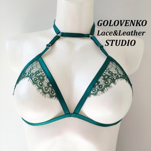 May include: A green lace and satin bralette with adjustable straps and a choker neckline. The bralette is designed with a triangle shape and features delicate lace trim. The brand name "GOLOVENKO Lace&Leather STUDIO" is printed on the top right corner of the image.