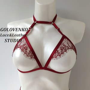 May include: Burgundy lace lingerie bra with adjustable straps and a choker style neckline. The bra has a delicate lace trim and is made of soft, stretchy fabric.  GOLOVENKO Lace&Leather STUDIO is printed on the bra.