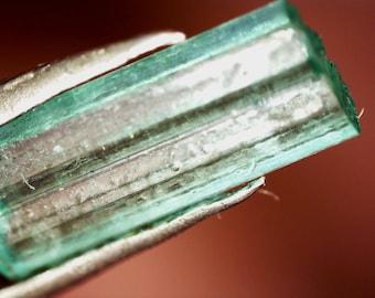 Cristal esmeralda bruto hexagonal duplo ligado na matriz
