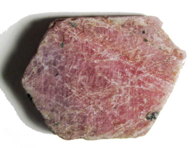 Peut inclure: Une pierre pr&eacute;cieuse de rubis rose brute avec une finition naturelle non polie. Le rubis a une forme l&eacute;g&egrave;rement irr&eacute;guli&egrave;re et une surface textur&eacute;e.