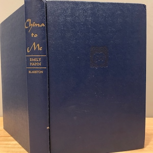 May include: A navy blue hardcover book titled "China to Me" by Emily Hahn. The book is published by Blakiston.