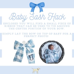 May include: A blue and white gingham bow with the initials "RJ" embroidered on it. The bow is lying on a white surface with a blue and white striped background. The text "Baby Sash Hack" is written in black cursive font. The text below explains how to use a ribbon to tie the bow around a baby for a photo.