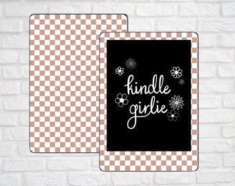 May include: A black Kindle case with the words "kindle girlie" in white script, surrounded by white flower illustrations. A matching cover with a brown and white checkered pattern is next to the case.