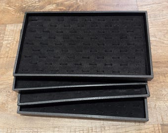 Set of four black velvet flocked slotted ring trays