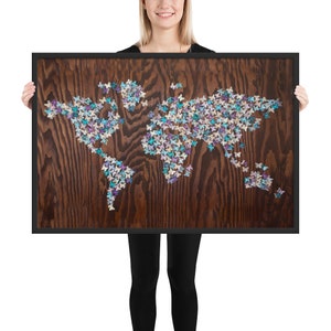 May include: A framed wood wall art piece featuring a world map made of colorful butterflies. The butterflies are in shades of blue, purple, and white.